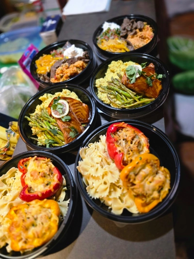 A week of personalized meal prep containers — salmon with asparagus, stuffed peppers, and beef bowls designed around a genetic nutrition plan